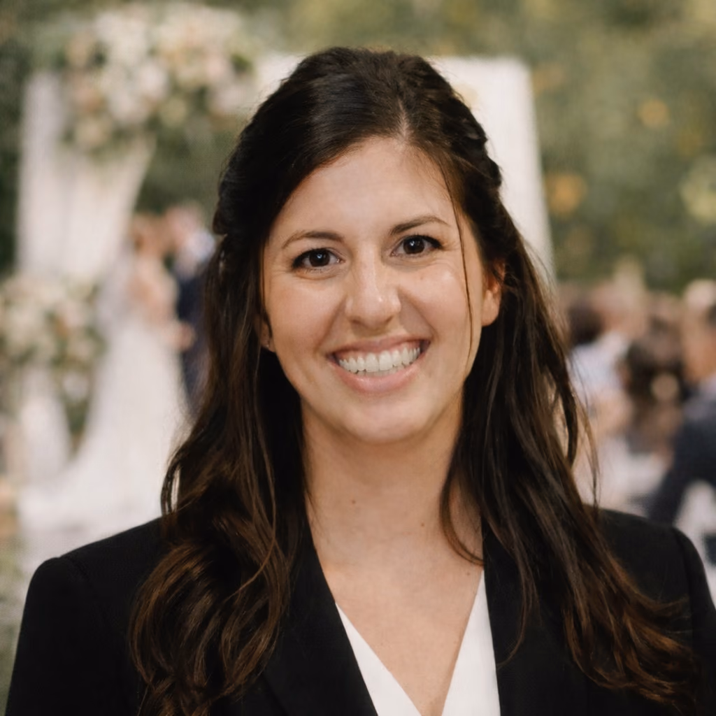 Sarah Sandoval smiling, wearing a black blazer over a white top